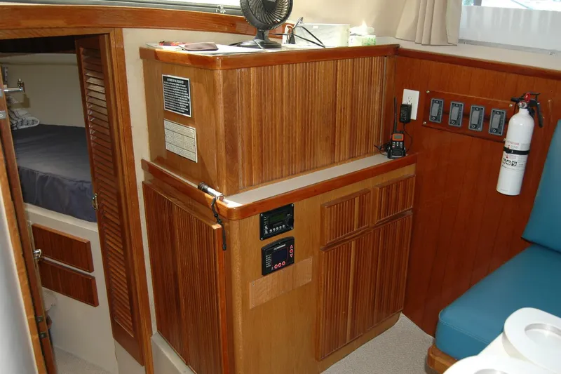 Vesper Yacht Photos Pics 1987 Bertram 33 Sport Fisherman interior with wood cabinetry and safety equipment.