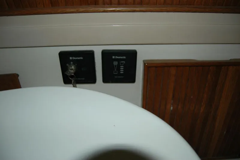 Vesper Yacht Photos Pics 1987 Bertram 33 Sport Fisherman interior with Dometic control panels and wooden cabinetry.