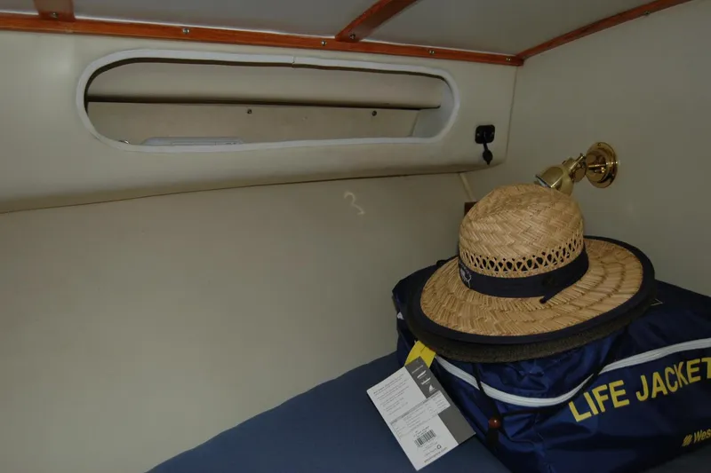 Vesper Yacht Photos Pics 1987 Bertram 33 Sport Fisherman cabin interior with straw hat and life jacket.
