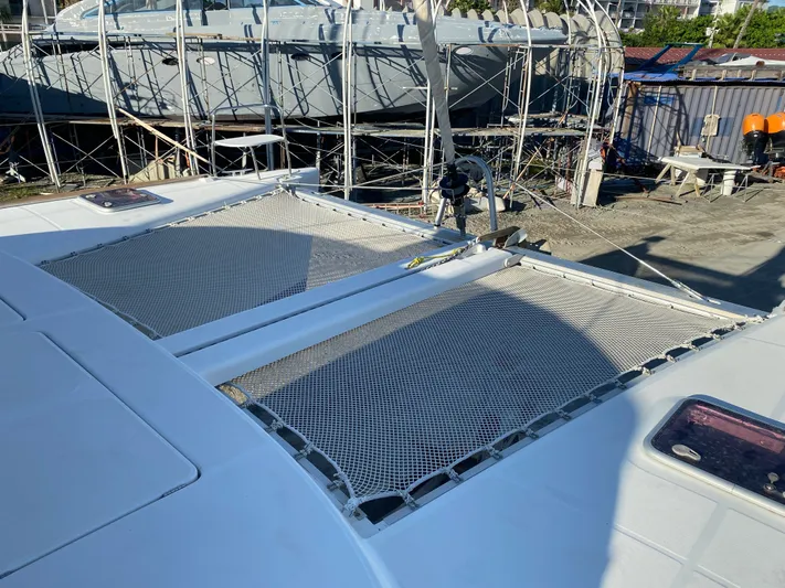 Eugenite Yacht Photos Pics 2013 Lagoon 380 catamaran with netted deck, docked in a boatyard.