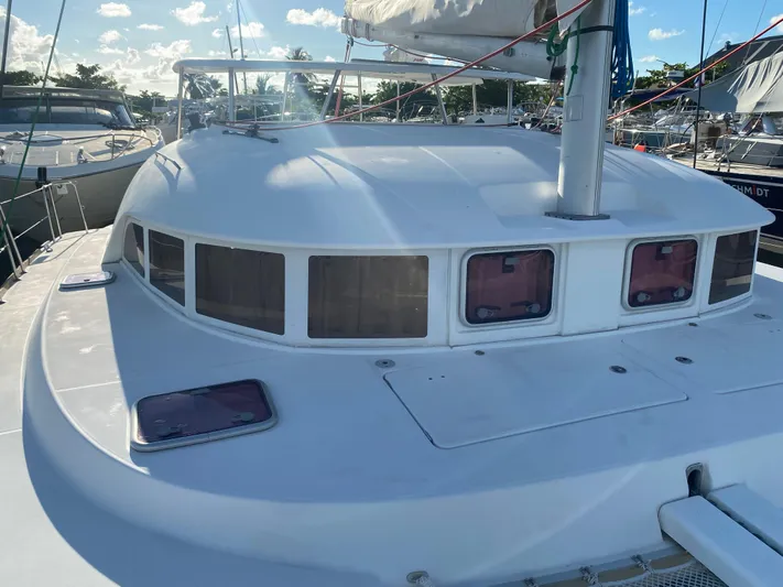 Eugenite Yacht Photos Pics 2013 Lagoon 380 catamaran deck with windows and mast, docked in marina.