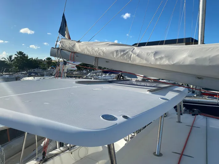 Eugenite Yacht Photos Pics 2013 Lagoon 380 catamaran deck with sail, docked under clear blue sky.