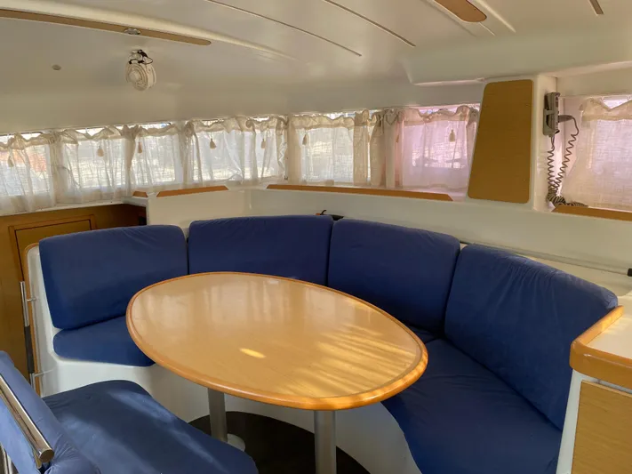 Eugenite Yacht Photos Pics Interior of 2013 Lagoon 380 catamaran with blue seating and oval table.