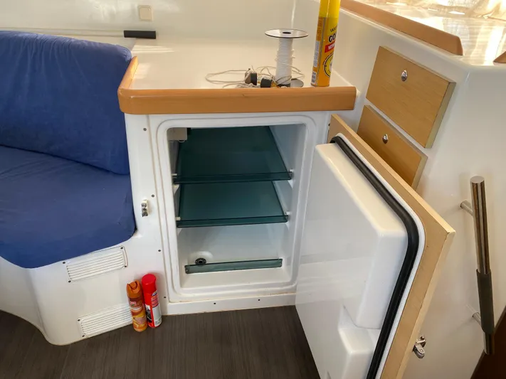 Eugenite Yacht Photos Pics Interior of a 2013 Lagoon 380 yacht with open mini fridge and blue seating.