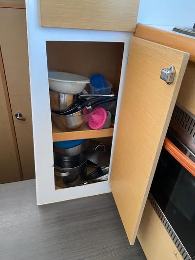 Eugenite Yacht Photos Pics Kitchen cabinet in Lagoon 380 yacht, 2013, storing various pots and kitchenware.