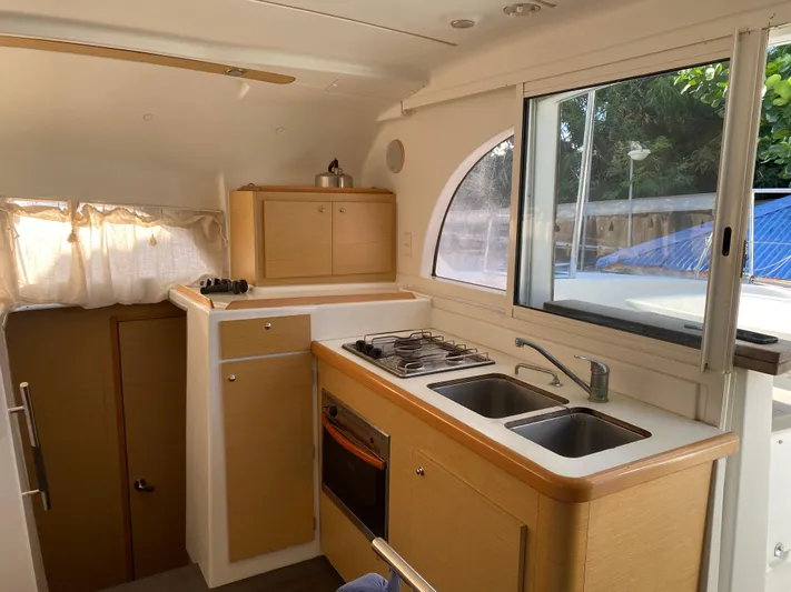 Eugenite Yacht Photos Pics Interior of 2013 Lagoon 380 catamaran kitchen with stove, sink, and window view.