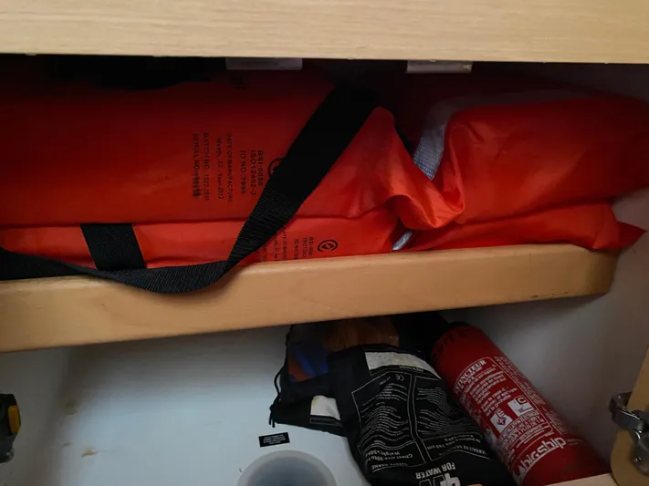 Eugenite Yacht Photos Pics Storage compartment with safety equipment on a 2013 Lagoon 380, including life jackets and a fire extinguisher.