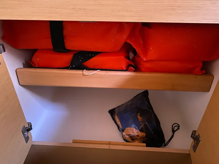 Eugenite Yacht Photos Pics Storage compartment in a 2013 Lagoon 380 catamaran with life jackets and a small bag.