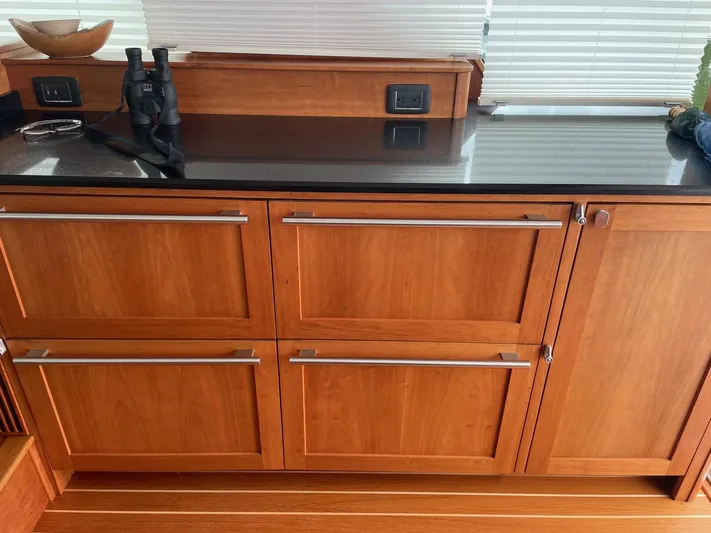 Last Resort Yacht Photos Pics Wooden cabinetry with black countertop in 2021 Sabre 58 Salon Express yacht interior.