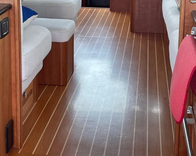 Last Resort Yacht Photos Pics Interior of 2021 Sabre 58 Salon Express with wooden flooring and white seating.