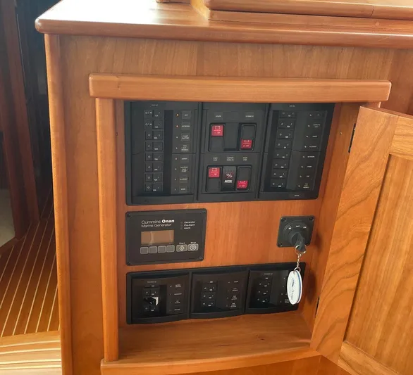 Last Resort Yacht Photos Pics Electrical panel inside 2021 Sabre 58 Salon Express yacht, featuring control switches and wooden cabinetry.