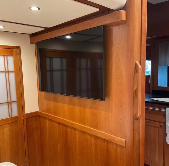 Last Resort Yacht Photos Pics Interior of 2021 Sabre 58 Salon Express with wall-mounted TV and wooden paneling.