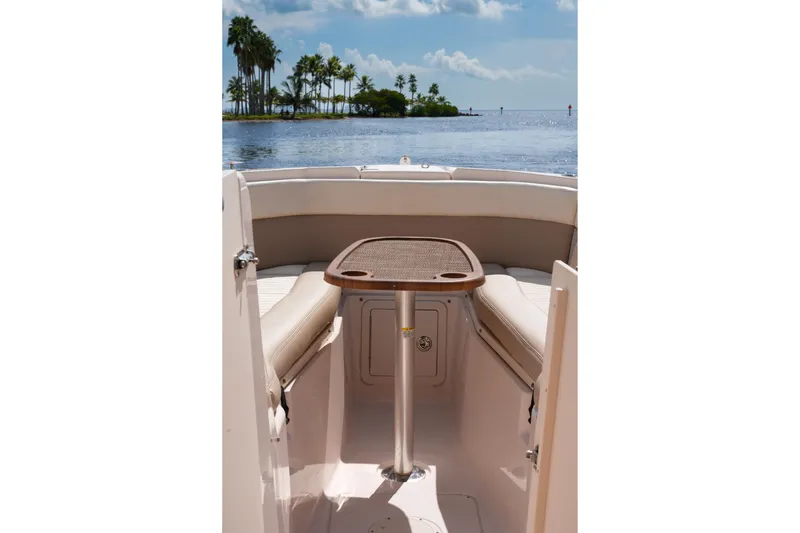  Yacht Photos Pics 2014 Grady-White Freedom 307 boat interior with table, overlooking serene water and palm trees.