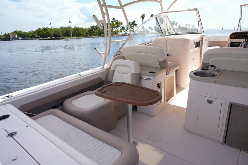  Yacht Photos Pics 2014 Grady-White Freedom 307 boat interior with seating and table, docked by scenic waterway.