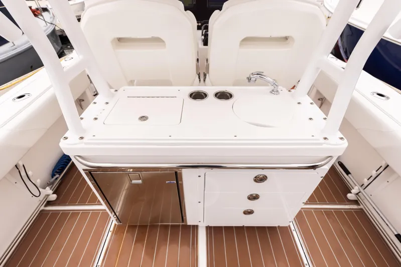 Pure Vida Yacht Photos Pics 2017 Edgewater Center Console boat interior with sink and storage compartments.