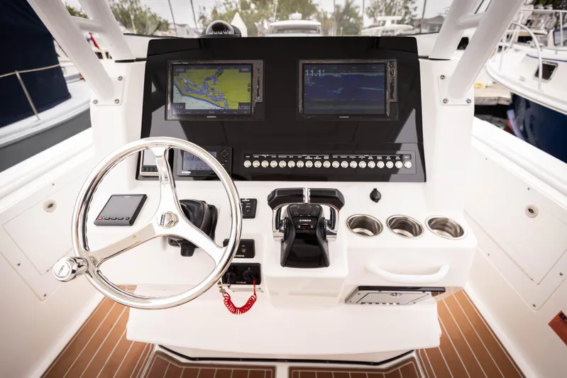 Pure Vida Yacht Photos Pics 2017 Edgewater Center Console boat dashboard with navigation screens and steering wheel.