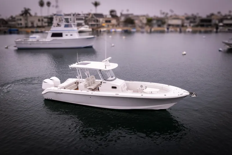 Pure Vida Yacht Photos Pics 2017 Edgewater Center Console boat on calm water, with marina in background.