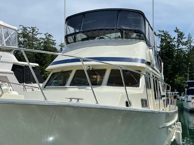 Venture 1 Yacht Photos Pics 1985 Tollycraft 43 yacht docked, surrounded by trees.
