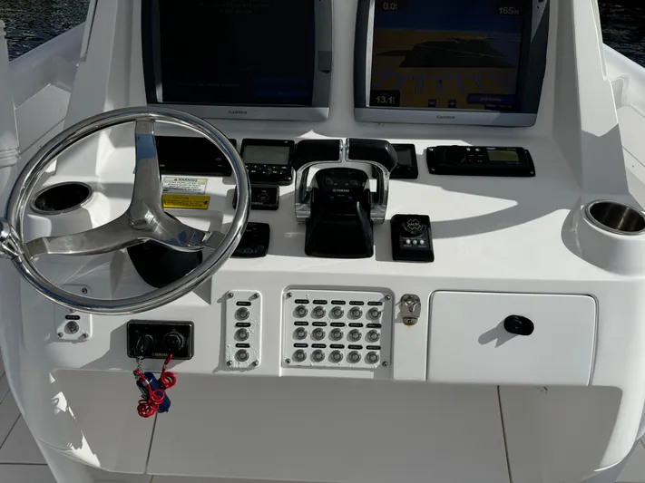No Name Yacht Photos Pics 2014 Intrepid 327 Center Console boat dashboard with steering wheel and navigation controls.