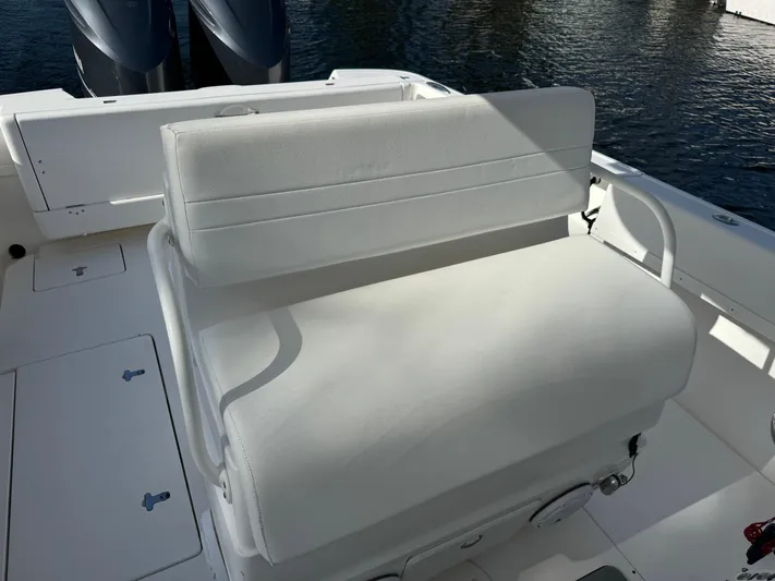 No Name Yacht Photos Pics White seating on a 2014 Intrepid 327 Center Console boat, with water in the background.