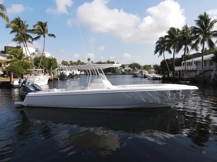 No Name Yacht Photos Pics 2014 Intrepid 327 Center Console boat on a sunny waterfront with palm trees.