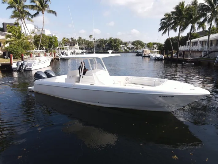 No Name Yacht Photos Pics 2014 Intrepid 327 Center Console boat on a calm waterway with palm trees.