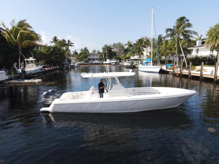 No Name Yacht Photos Pics 2014 Intrepid 327 Center Console boat cruising in a scenic, palm-lined waterway.