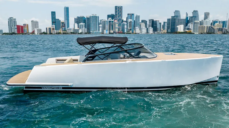  Yacht Photos Pics 2023 VanDutch 32 yacht cruising on water with city skyline in background.