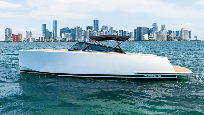  Yacht Photos Pics 2023 VanDutch 32 yacht cruising on water with city skyline in background.