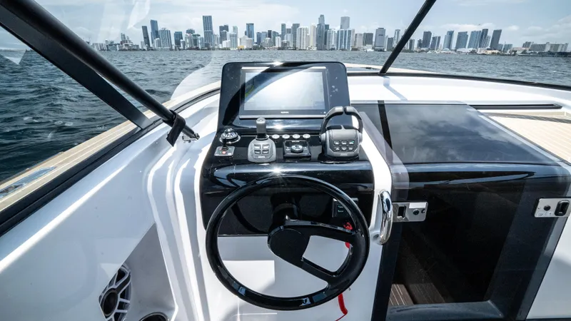  Yacht Photos Pics 2023 VanDutch 32 yacht helm with city skyline in the background.