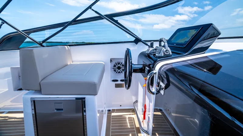  Yacht Photos Pics 2023 VanDutch 32 yacht cockpit with modern controls and seating, under a clear blue sky.