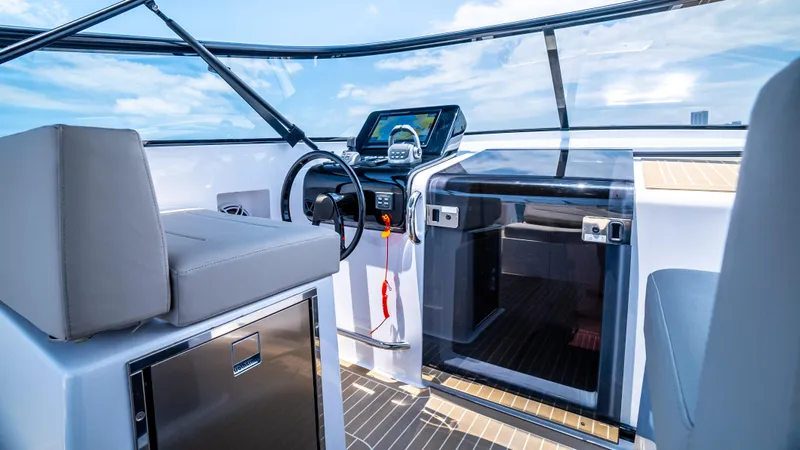  Yacht Photos Pics 2023 VanDutch 32 yacht cockpit with modern controls and seating, under a clear blue sky.