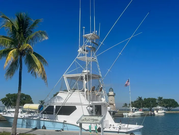  Yacht Photos Pics 1990 Hatteras 45 Convertible yacht docked near palm tree and lighthouse.