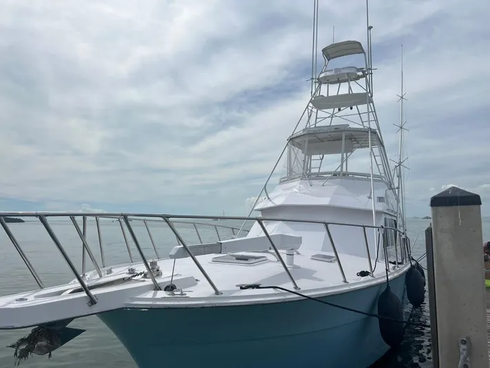  Yacht Photos Pics 1990 Hatteras 45 Convertible yacht docked under cloudy sky.