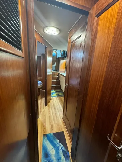  Yacht Photos Pics Interior hallway of 1990 Hatteras 45 Convertible yacht with wooden paneling and modern lighting.