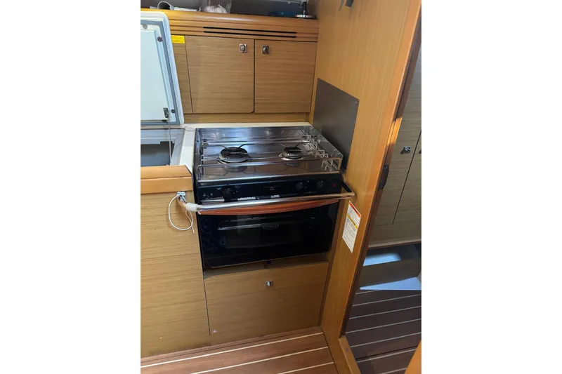  Yacht Photos Pics 2009 Jeanneau Sun Odyssey 39i yacht kitchen with stove and wooden cabinetry.