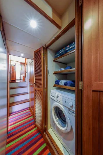 My Lindavia Yacht Photos Pics Laundry area in 2012 Kadey-Krogen 44 yacht with washer, shelves, and colorful carpet.