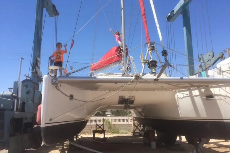 Let It Be Yacht Photos Pics 2003 Fountaine Pajot Bahia catamaran on dry dock with two people aboard.