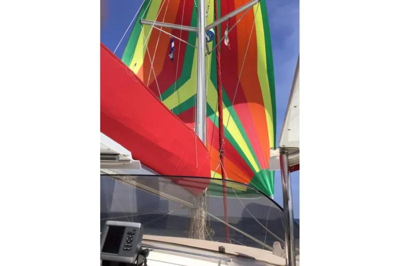 Let It Be Yacht Photos Pics Colorful sails on a 2003 Fountaine Pajot Bahia catamaran against a clear sky.