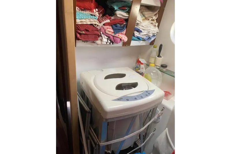 Let It Be Yacht Photos Pics Laundry area on 2003 Fountaine Pajot Bahia catamaran with washing machine and shelves.