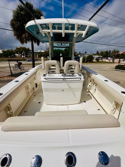 Priced To Sell! Yacht Photos Pics 2020 Boston Whaler 280 Outrage boat interior with seating and console, under a blue sky.