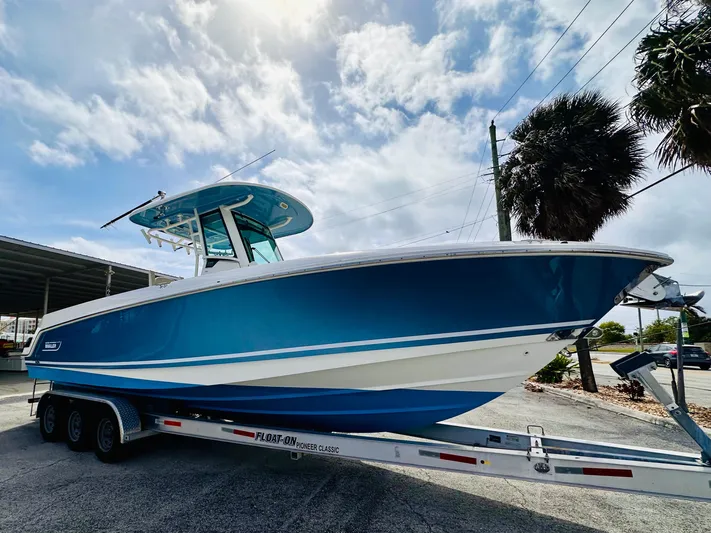 Priced To Sell! Yacht Photos Pics 2020 Boston Whaler 280 Outrage boat on trailer under cloudy sky.