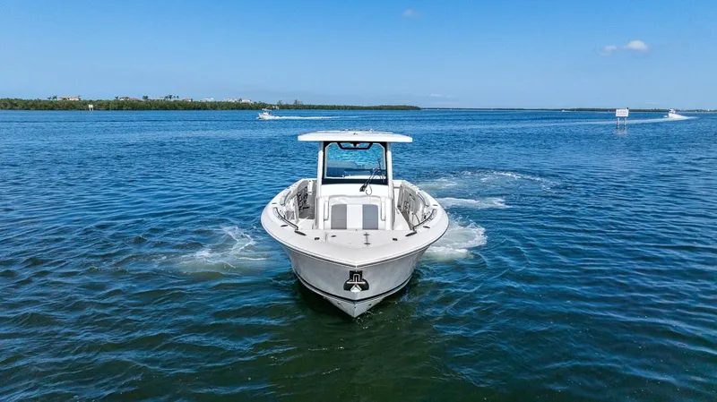  Yacht Photos Pics 2021 Pursuit S 328 Sport boat cruising on open water under clear blue skies.