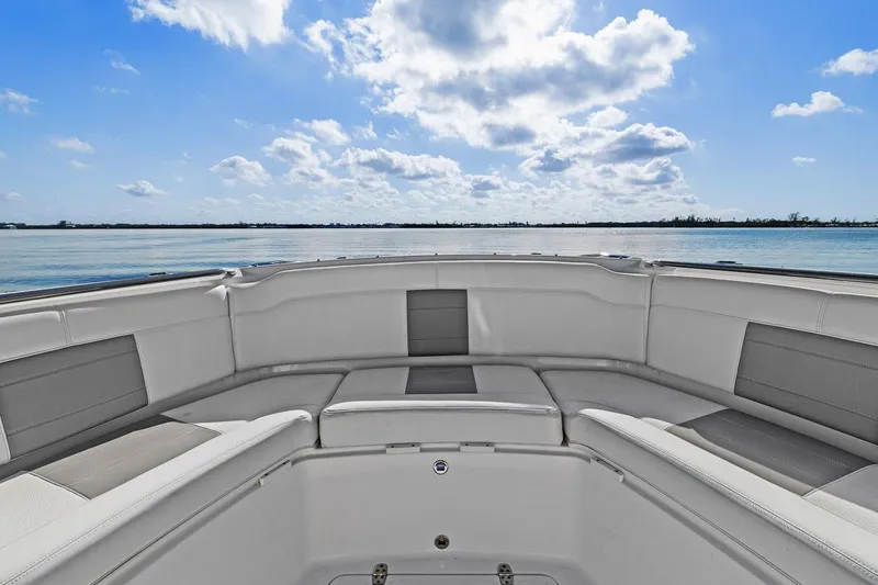  Yacht Photos Pics 2021 Pursuit S 328 Sport boat interior with cushioned seating, ocean view, and blue sky.