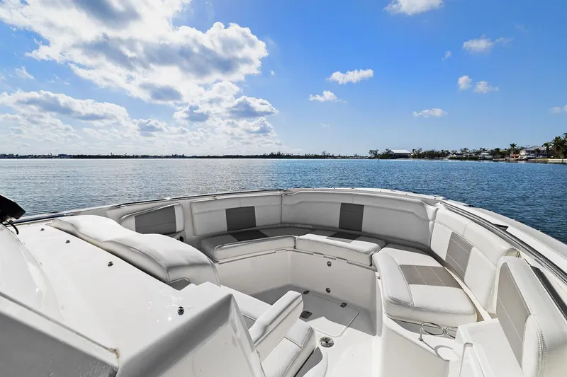  Yacht Photos Pics 2021 Pursuit S 328 Sport boat with spacious seating, overlooking a serene water view.