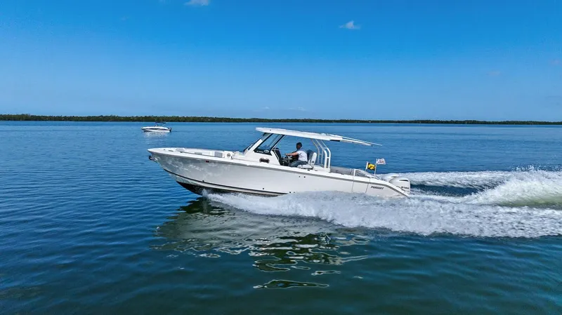  Yacht Photos Pics 2021 Pursuit S 328 Sport boat cruising on calm blue water.