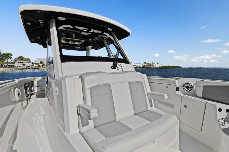  Yacht Photos Pics 2021 Pursuit S 328 Sport boat with seating, on calm water.