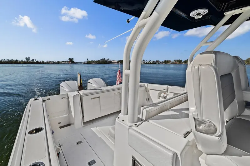  Yacht Photos Pics 2021 Pursuit S 328 Sport boat interior with seating, overlooking calm waters.
