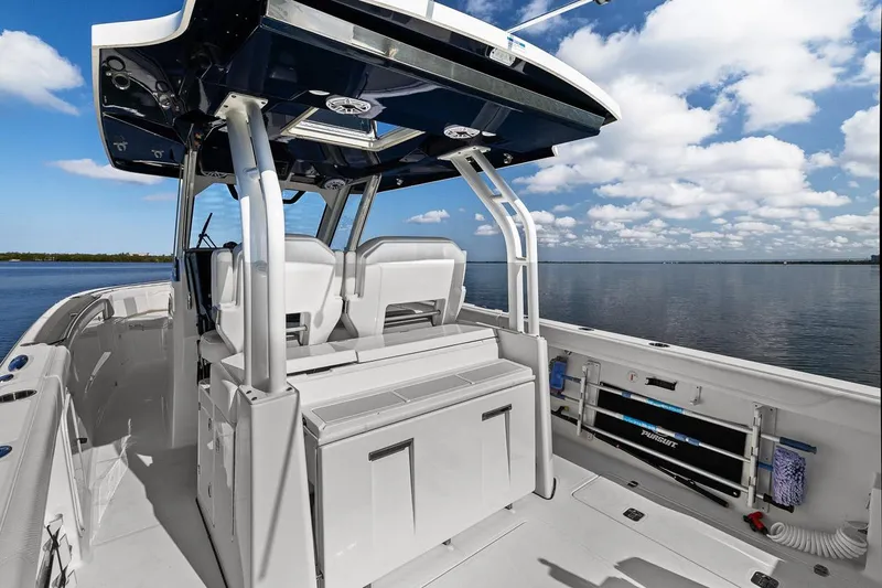  Yacht Photos Pics 2021 Pursuit S 328 Sport boat interior with seating, under a blue sky.