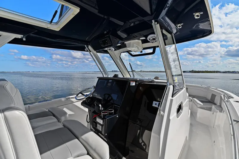  Yacht Photos Pics 2021 Pursuit S 328 Sport boat interior with helm, seats, and ocean view.